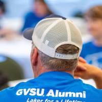 Man wearing GVSU Alumni Laker for a Lifetime shirt sitting at table